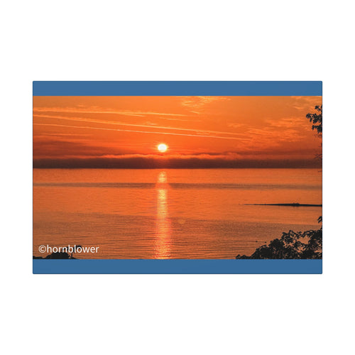 Canvas print of an orange sunset over calm water by Hornblower Photography